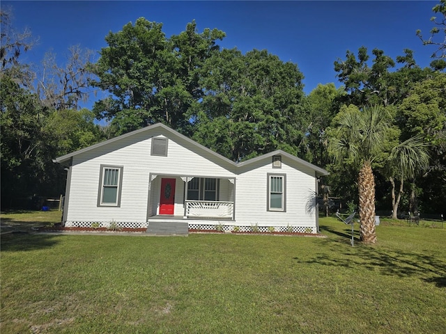326 SE 2nd St, Williston, FL 32696 - view of front of property featuring a porch, a front yard, and view of scattered trees