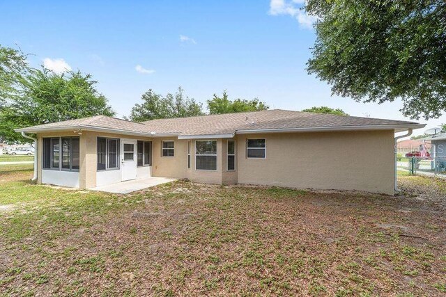 4886 NW 30th Pl, Ocala, FL 34482 - rear view of house with stucco siding and a sunroom