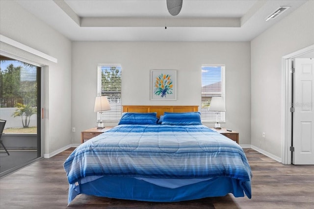 808 Overlook Grove Dr, Winter Haven, FL 33884 - bedroom featuring wood finished floors, multiple windows, and a tray ceiling
