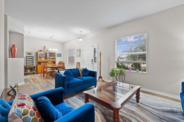 808 Overlook Grove Dr, Winter Haven, FL 33884 - living room with a chandelier, light wood-style flooring, and baseboards