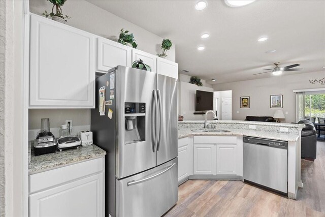 808 Overlook Grove Dr, Winter Haven, FL 33884 - kitchen with stainless steel appliances, a sink, open floor plan, a peninsula, and white cabinets