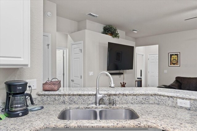 808 Overlook Grove Dr, Winter Haven, FL 33884 - kitchen featuring a sink, light stone counters, white cabinets, and open floor plan