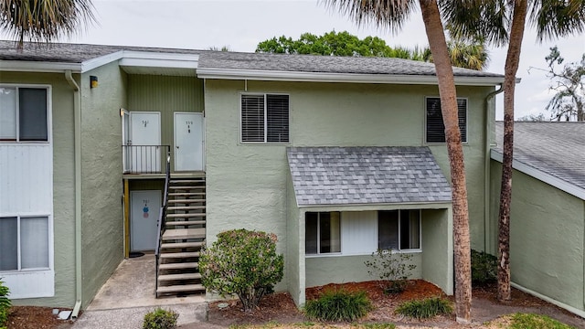 view of front of house with stucco siding and roof with shingles