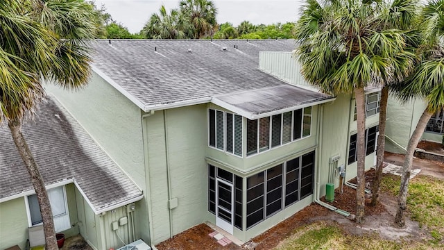 back of property featuring roof with shingles and stucco siding
