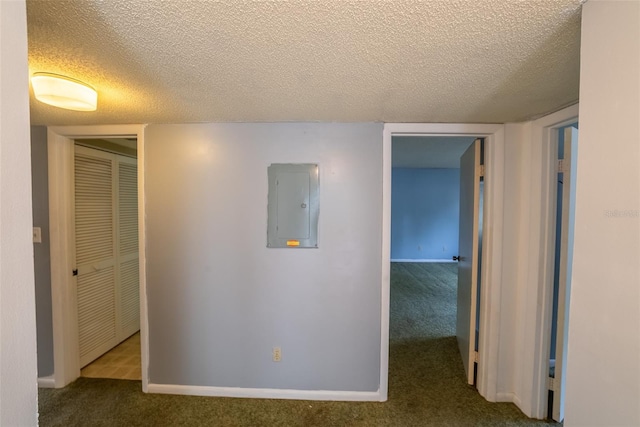 hallway with electric panel, carpet flooring, a textured ceiling, and baseboards