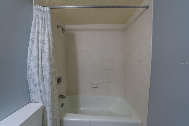 full bathroom featuring toilet, shower / bath combo with shower curtain, and a textured ceiling
