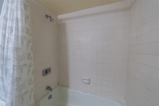 full bath featuring shower / bathtub combination with curtain and a textured ceiling