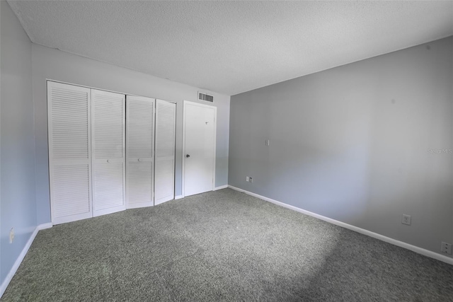 unfurnished bedroom featuring carpet flooring, a closet, a textured ceiling, and baseboards