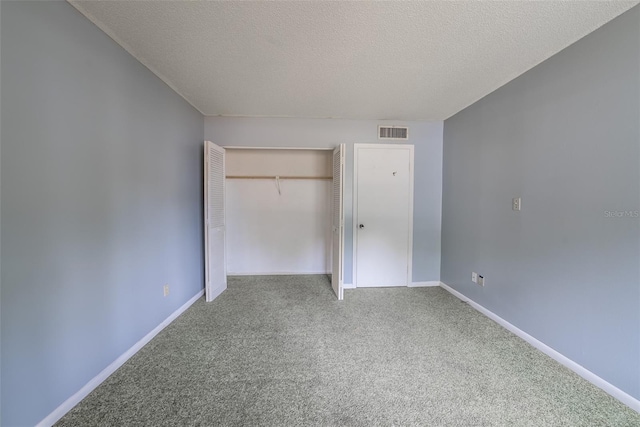 unfurnished bedroom featuring carpet flooring, a closet, a textured ceiling, and baseboards