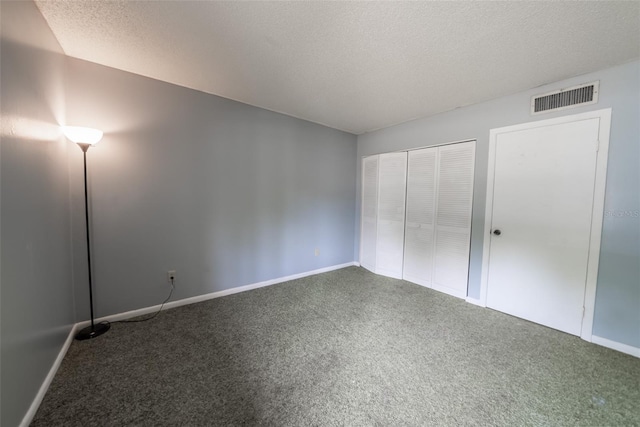 unfurnished bedroom with carpet floors, baseboards, a textured ceiling, and a closet
