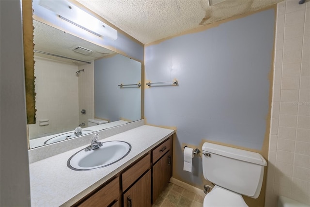 full bath featuring toilet, a textured ceiling, vanity, and baseboards
