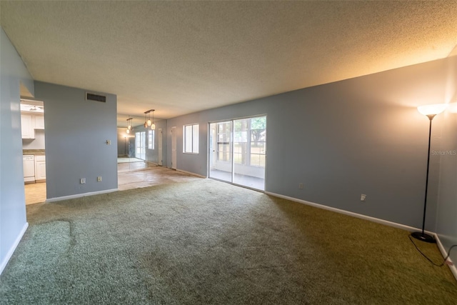 carpeted spare room featuring a textured ceiling and baseboards