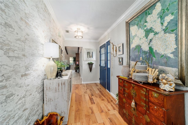 hallway with light wood-style flooring, crown molding, and baseboards