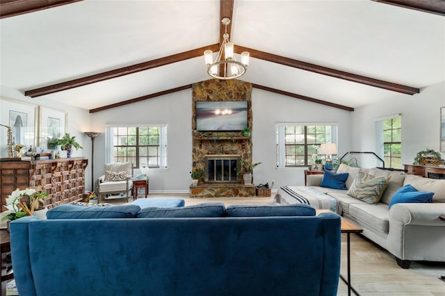 living room with healthy amount of natural light, a stone fireplace, light wood-type flooring, and a chandelier