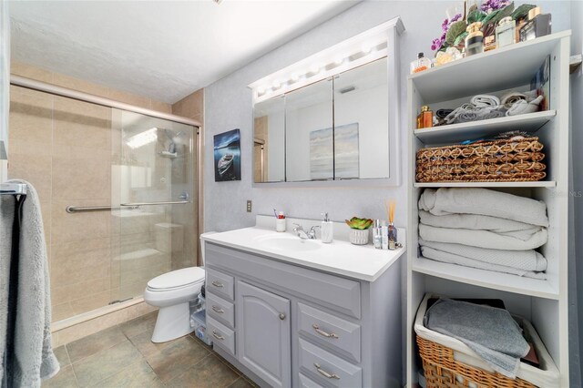 bathroom featuring vanity, a shower stall, and toilet