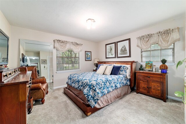 bedroom with light carpet and baseboards