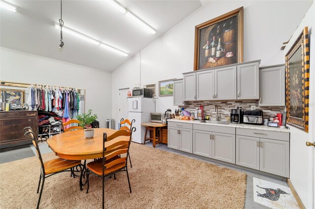 dining area featuring high vaulted ceiling