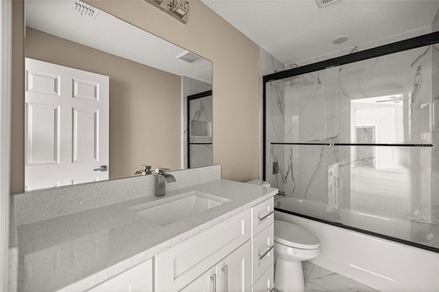 bathroom with marble look tiles, toilet, vanity, and combined bath / shower with glass door