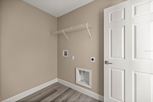 washroom with electric dryer hookup, hookup for a washing machine, baseboards, and wood finished floors
