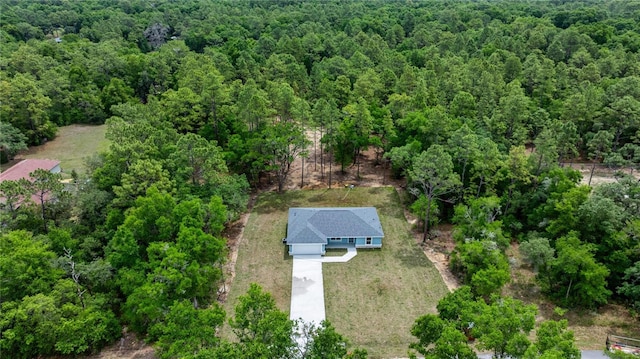 aerial view of property and surrounding area featuring a forest