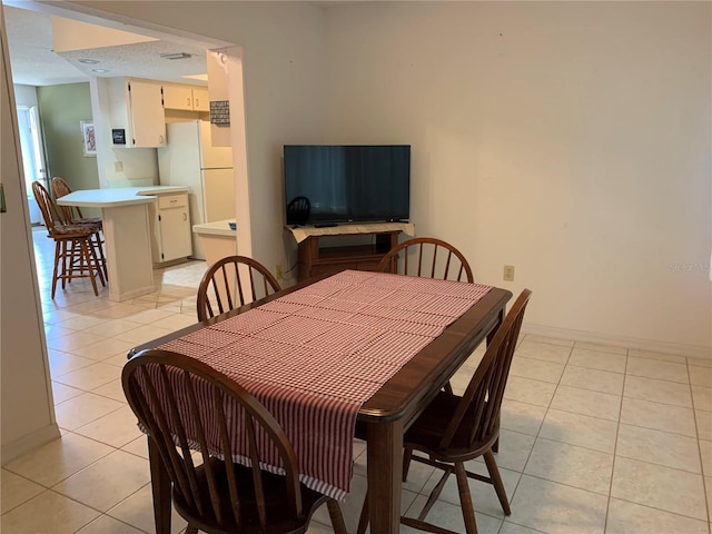 dining area featuring light tile patterned floors and baseboards