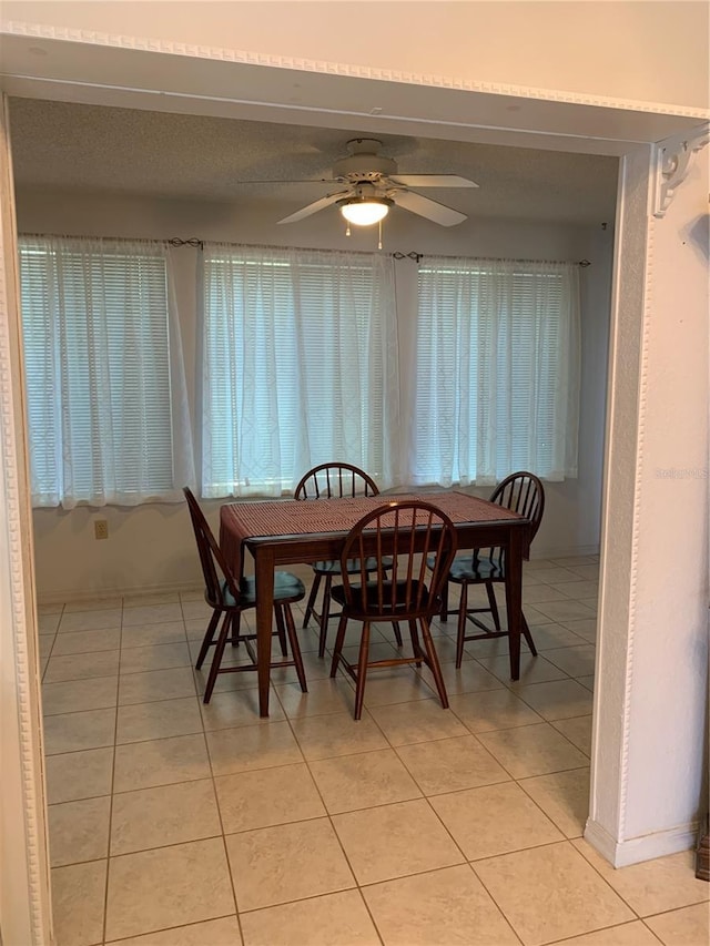 dining room featuring light tile patterned floors, ceiling fan, and baseboards