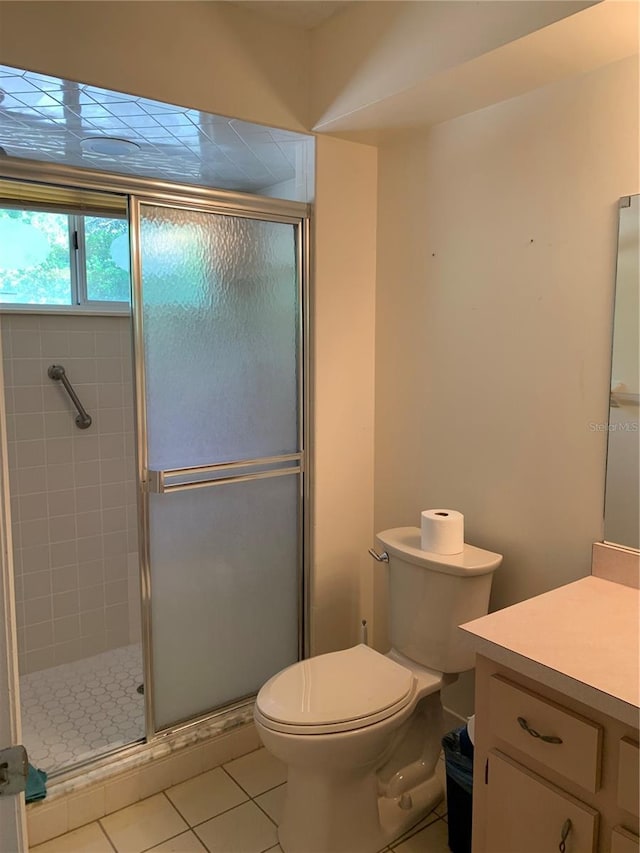 full bath featuring tile patterned flooring, a shower stall, toilet, and vanity