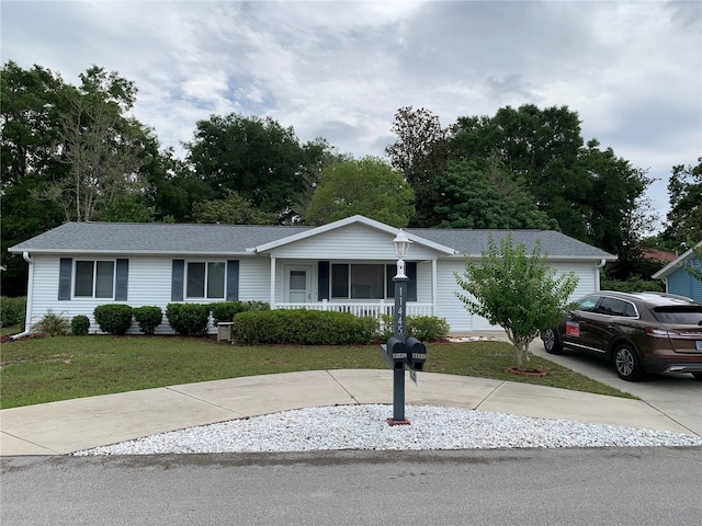 11445 SW 84th Avenue Rd, Ocala, FL 34481 - ranch-style home with a porch, a front yard, driveway, and a shingled roof