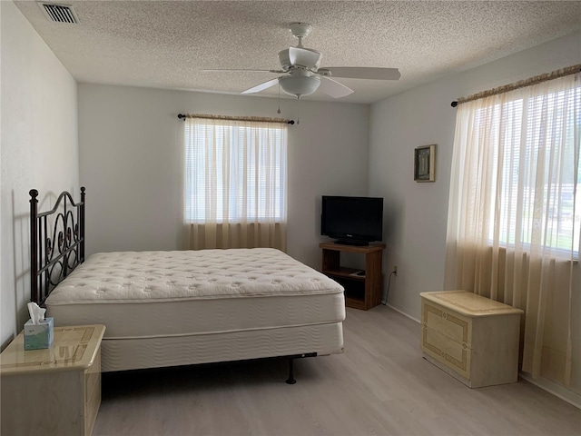 11445 SW 84th Avenue Rd, Ocala, FL 34481 - bedroom with light wood-style floors, a textured ceiling, ceiling fan, and baseboards