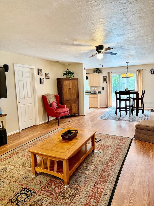 3106 Silver Palm Dr, Edgewater, FL 32141 - living area with a ceiling fan, light wood-style floors, a textured ceiling, and baseboards