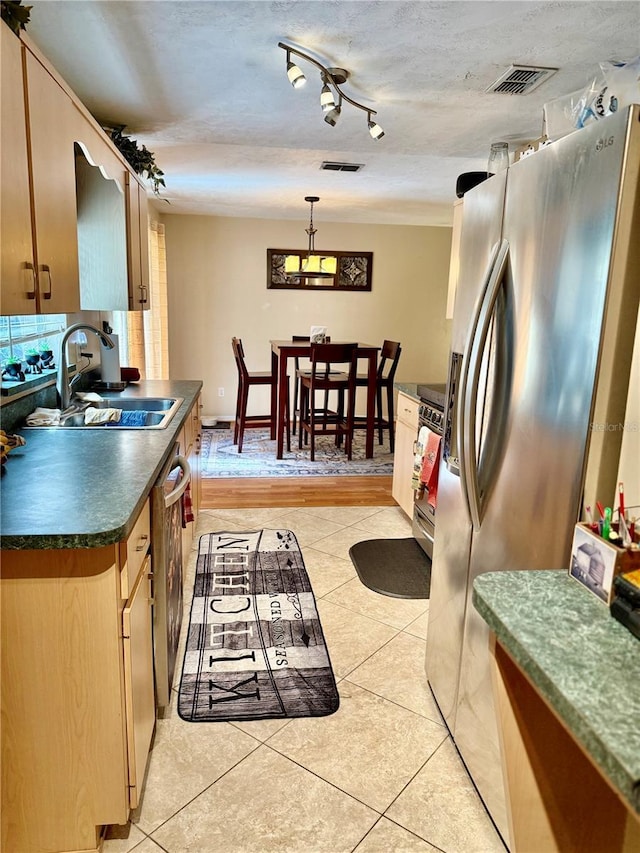 3106 Silver Palm Dr, Edgewater, FL 32141 - kitchen featuring a sink, appliances with stainless steel finishes, dark countertops, light tile patterned flooring, and hanging light fixtures
