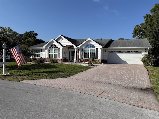 ranch-style house with a garage, decorative driveway, a front lawn, and brick siding