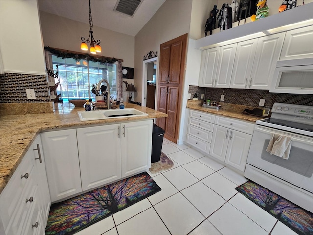kitchen with white appliances, vaulted ceiling, a sink, tasteful backsplash, and a peninsula