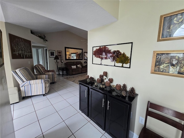 living area featuring vaulted ceiling and light tile patterned flooring