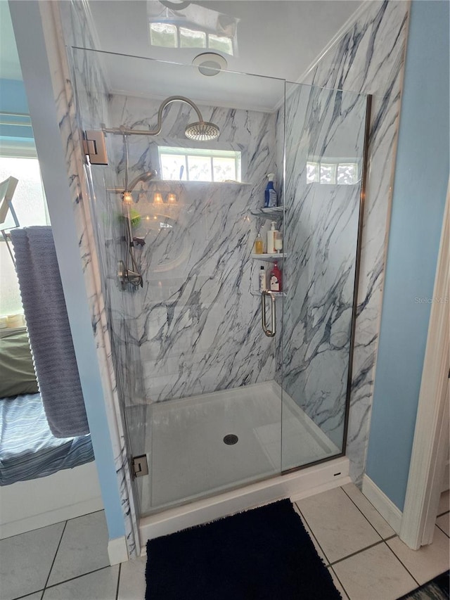 full bath featuring a marble finish shower, tile patterned floors, and baseboards