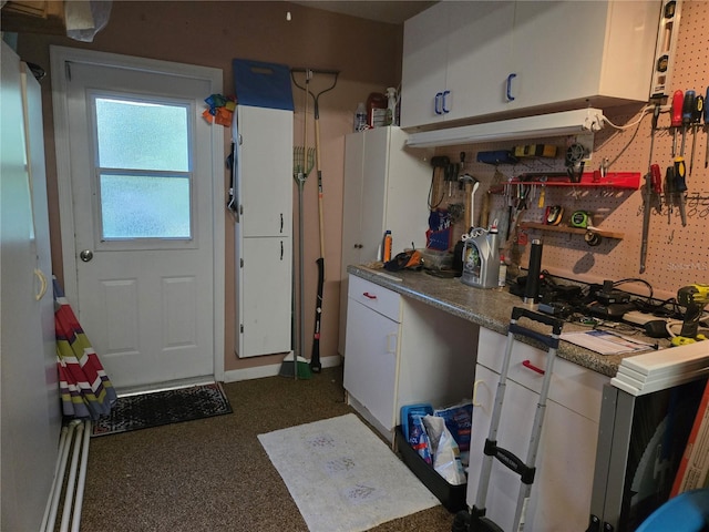 kitchen with white cabinetry and dark colored carpet