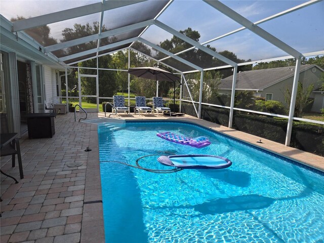 outdoor pool with a patio and glass enclosure
