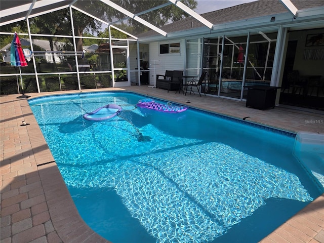 outdoor pool featuring a patio area and glass enclosure