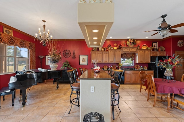 4725 County Road 121d, Wildwood, FL 34785 - kitchen with freestanding refrigerator, light tile patterned flooring, a chandelier, a breakfast bar area, and ornamental molding