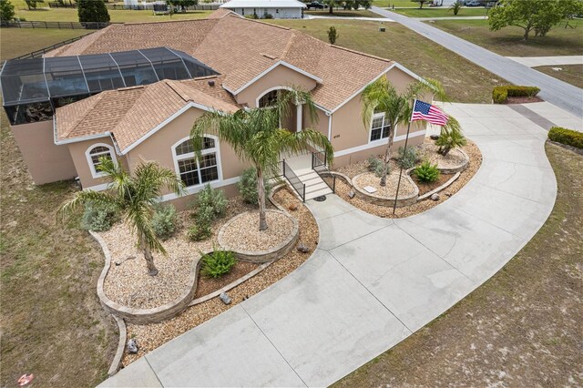 4725 County Road 121d, Wildwood, FL 34785 - view of front of house featuring stucco siding, curved driveway, a shingled roof, and a front lawn