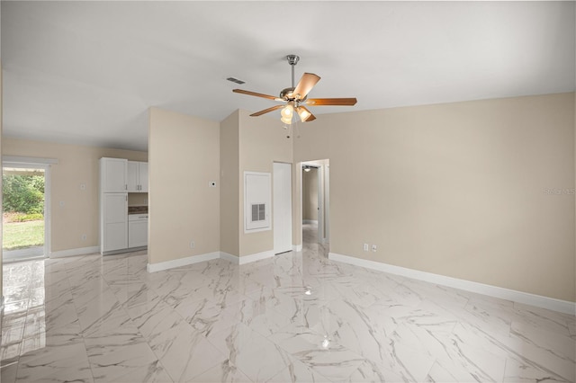 empty room featuring a ceiling fan, baseboards, lofted ceiling, and light marble finish flooring