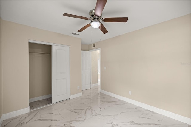 unfurnished bedroom featuring light marble finish flooring, a closet, baseboards, and a ceiling fan