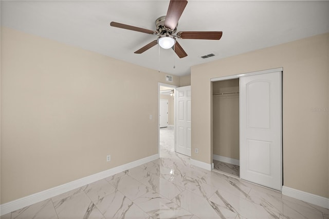 unfurnished bedroom featuring light marble finish floors, baseboards, a closet, and ceiling fan
