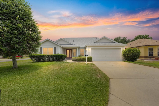 1402 Arredondo Dr, The Villages, FL 32162 - ranch-style house featuring concrete driveway, an attached garage, a front yard, and a shingled roof