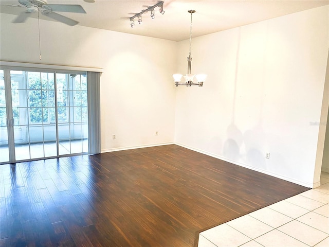 1402 Arredondo Dr, The Villages, FL 32162 - empty room with a chandelier, wood finished floors, a ceiling fan, baseboards, and rail lighting