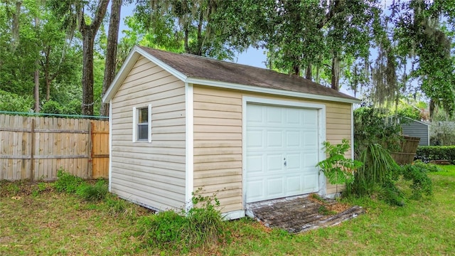 detached garage featuring fence