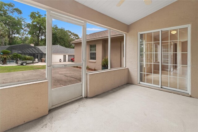 unfurnished sunroom featuring lofted ceiling and ceiling fan