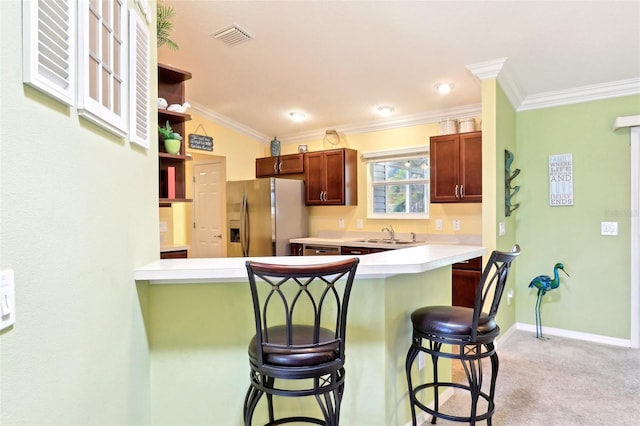 kitchen with stainless steel fridge, a kitchen breakfast bar, a sink, crown molding, and open shelves
