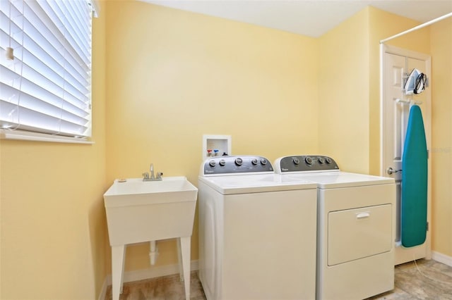 washroom featuring washer and dryer and baseboards