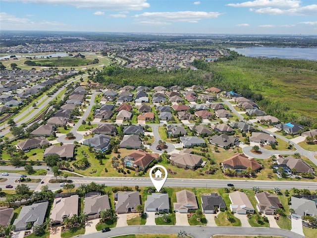 aerial view of property's location with a large body of water and nearby suburban area